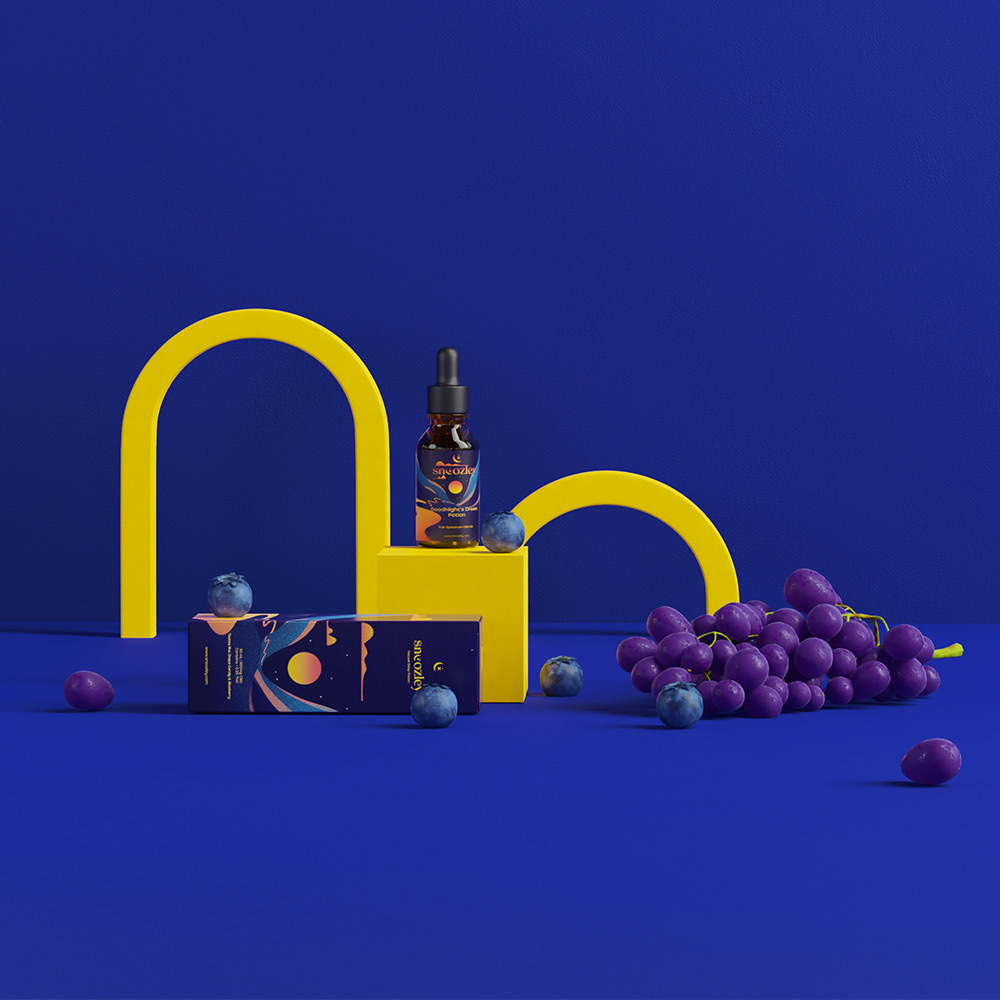 Snoozley GoodNight’s Dream Potion bottle and packaging staged with yellow arches and grapes on a deep-blue set
